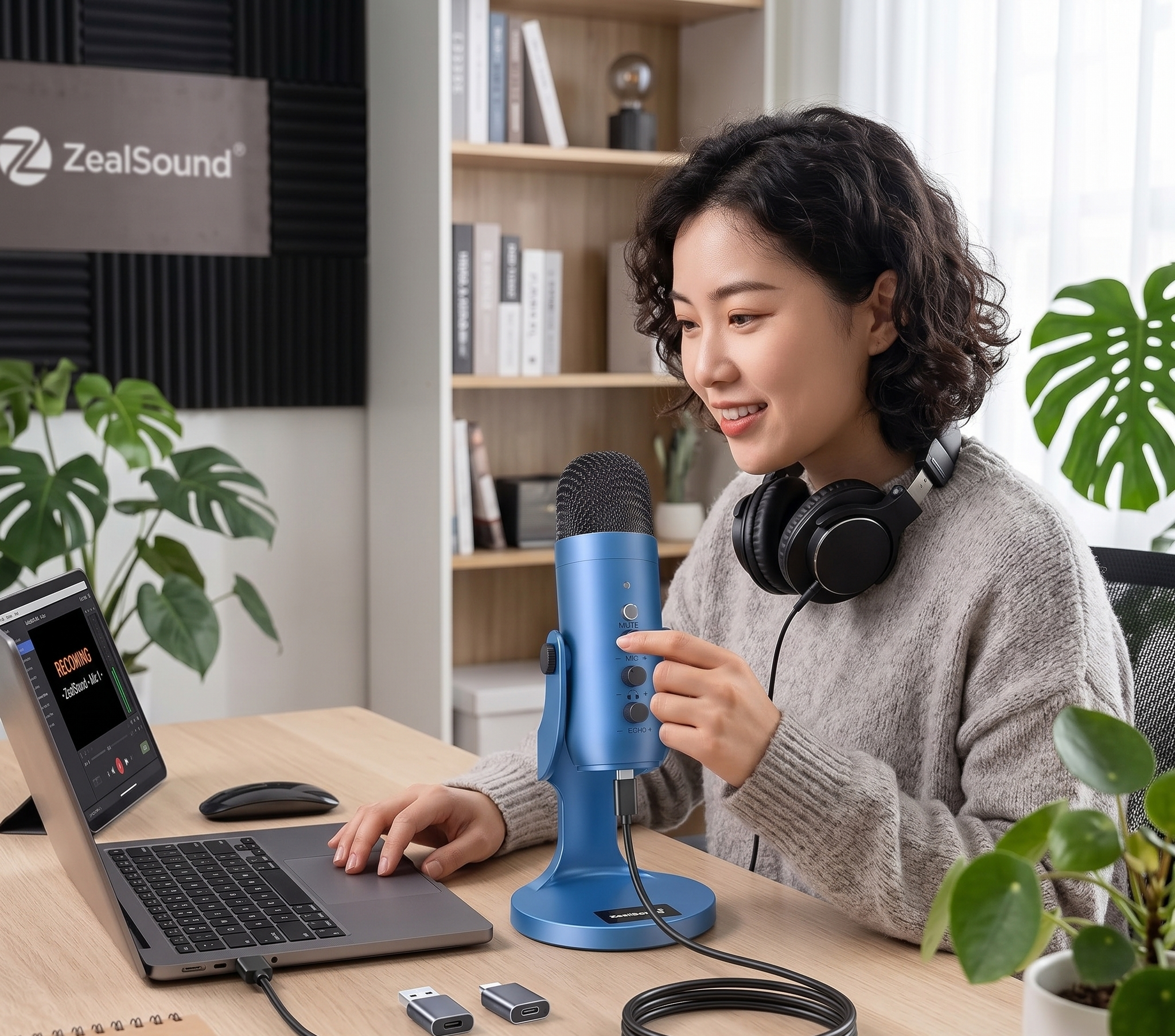 Woman recording podcast at desk with blue microphone, laptop, and headphones in home studio setting